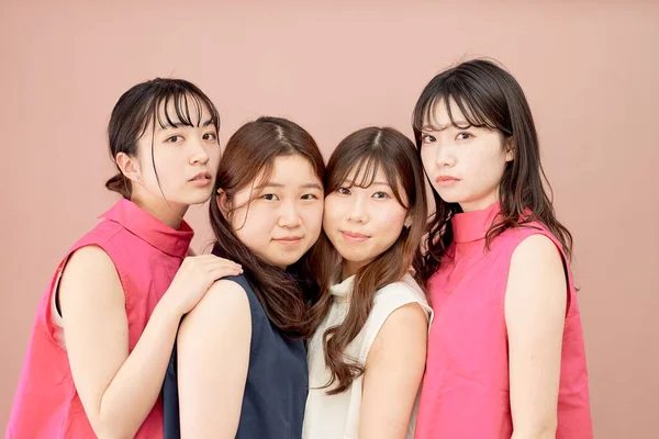 背景色の前に立つ4人の若い女性のグループ — ストック写真