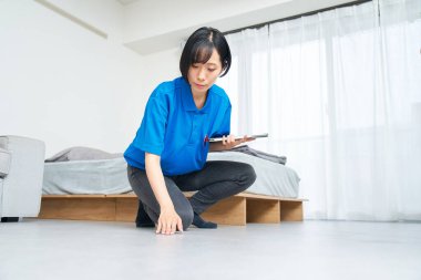 İş elbiseli bir kadın odanın durumunu kontrol ediyor.