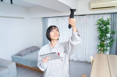 İş elbiseli bir kadın odayı kontrol ediyor.