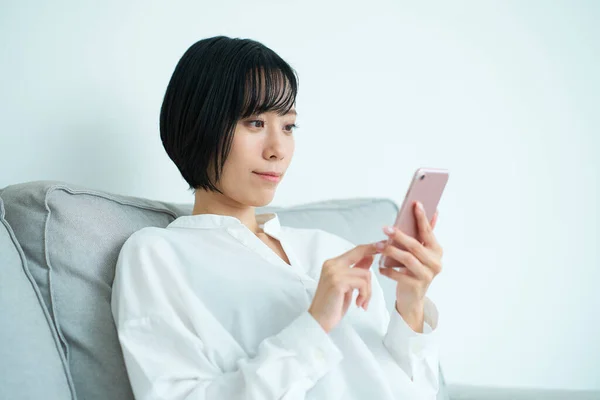 Frau Sitzt Auf Sofa Und Benutzt Smartphone Zimmer — Stockfoto