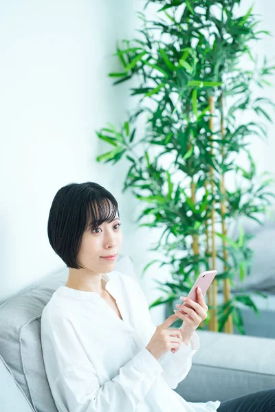 Frau Sitzt Auf Sofa Und Benutzt Smartphone Zimmer — Stockfoto