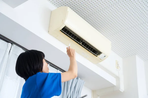 Een Vrouw Werkkleding Die Conditie Van Airconditioner Controleert — Stockfoto