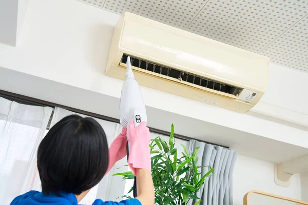 Eine Frau Arbeitskleidung Putzt Die Klimaanlage — Stockfoto