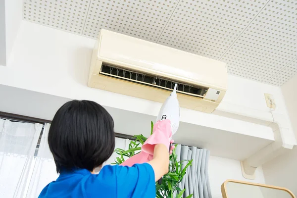 Eine Frau Arbeitskleidung Putzt Die Klimaanlage — Stockfoto