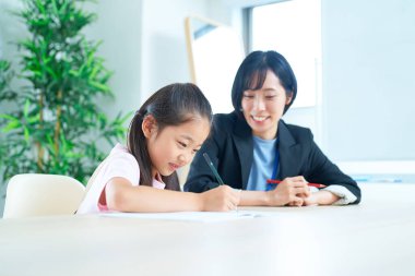 Çalışan bir kız ve odada desteklemek için takım elbiseli bir kadın.