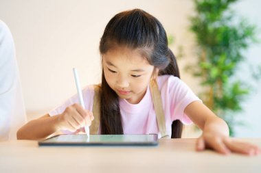 Odada tabletle oynayan çocuk