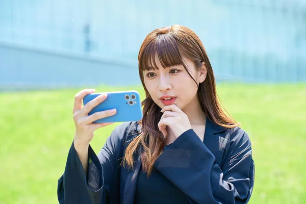 Uma Jovem Mulher Olhando Para Uma Tela Smartphone Com Uma — Fotografia de Stock