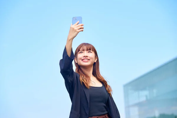 Ung Kvinna Som Håller Smartphone Den Blå Himlen — Stockfoto