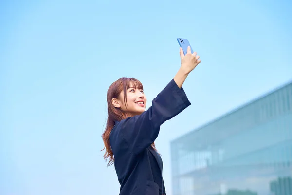 Ung Kvinna Som Håller Smartphone Den Blå Himlen — Stockfoto