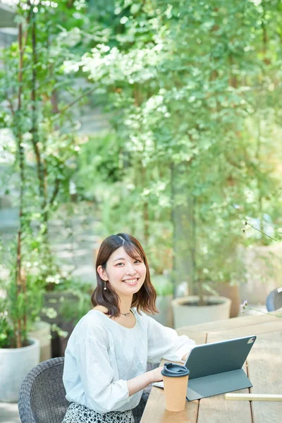 一个笑着在街角操作平板电脑的女人 — 图库照片