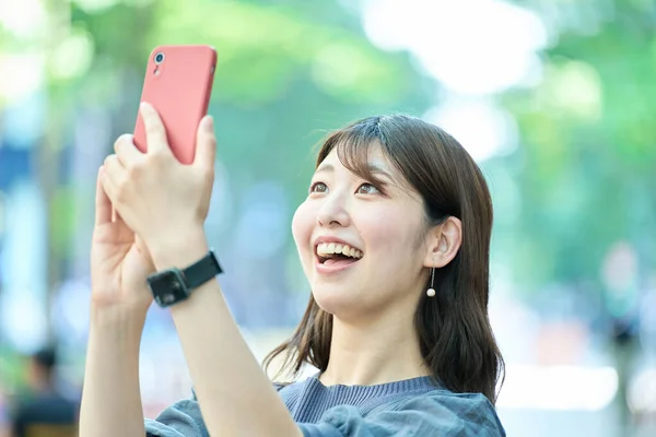 Ung Kvinna Som Håller Smartphone Utomhus — Stockfoto