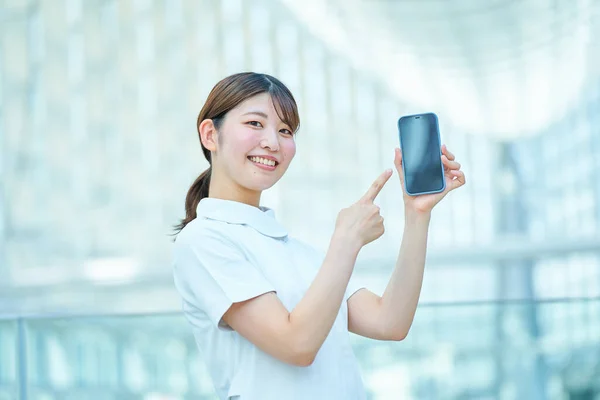 Beyaz Önlüklü Bir Kadın Elinde Dijital Bir Cihaz Tutuyor — Stok fotoğraf