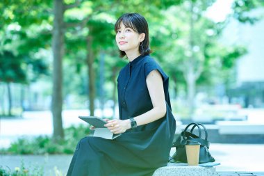 Dışarıda tablet kullanan genç bir kadın.