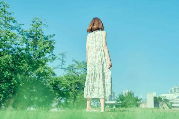 ゆったりとした表情で緑の空間を歩く若い女性 — ストック写真