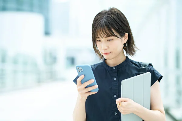 外でスマートフォンを操作する若い女性 — ストック写真