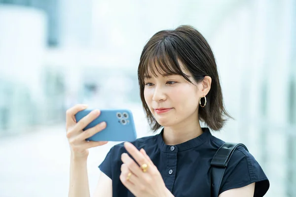 Dışarıdaki Akıllı Telefon Ekranına Bakan Genç Bir Kadın — Stok fotoğraf
