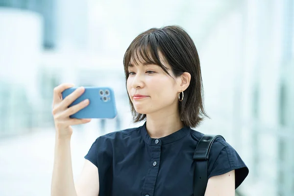 Dışarıdaki Akıllı Telefon Ekranına Bakan Genç Bir Kadın — Stok fotoğraf