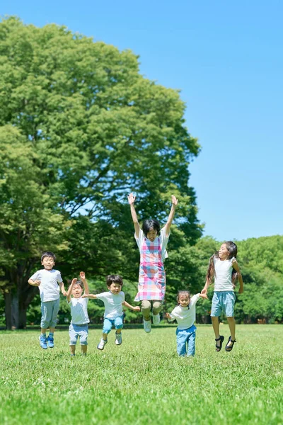 Children Woman Jumping Green Space — Stock Photo, Image