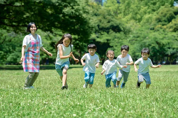 Des Enfants Courent Une Femme Regarde Dans Parc — Photo