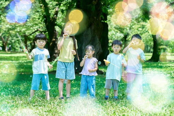 公園で石鹸バブルで遊んでいる子供たち — ストック写真