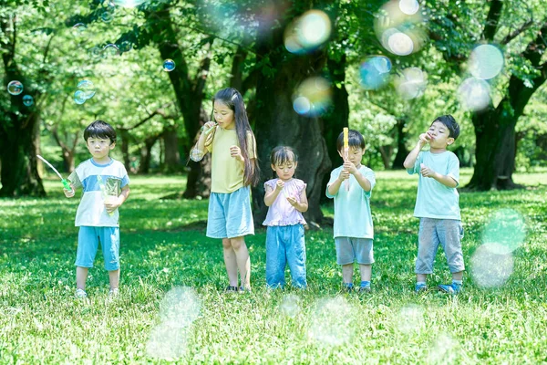 公園で石鹸バブルで遊んでいる子供たち — ストック写真
