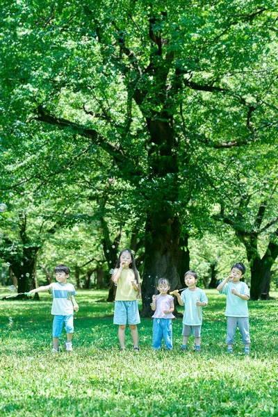 Dzieci Bawią Się Bańkami Mydlanymi Parku — Zdjęcie stockowe