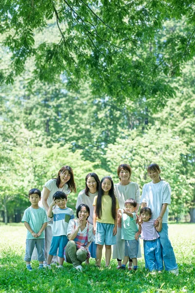 Group photo of children, parents and a female teacher in the park