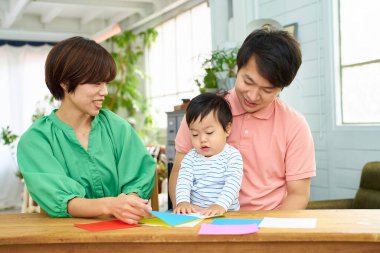 Ebeveyn ve çocuk evde origami oynuyorlar