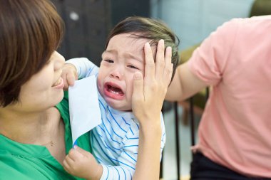 Ağlayan bebekler ve birbirine sarılan ebeveynler