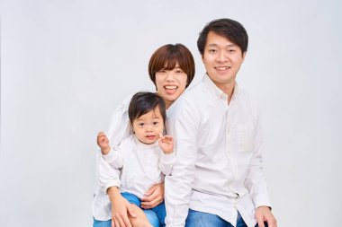 Aile gülümsüyor ve beyaz arka planda sıraya giriyor.