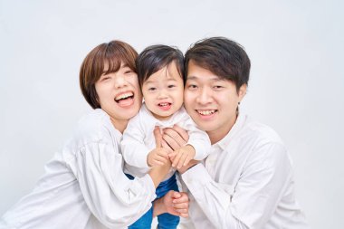 Aile gülümsüyor ve beyaz arka planda sıraya giriyor.