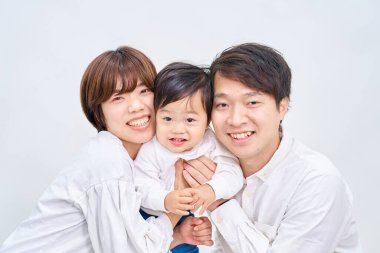 Aile gülümsüyor ve beyaz arka planda sıraya giriyor.