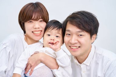 Aile gülümsüyor ve beyaz arka planda sıraya giriyor.