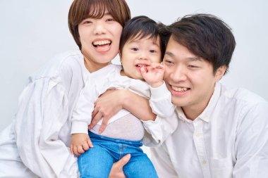 Aile gülümsüyor ve beyaz arka planda sıraya giriyor.