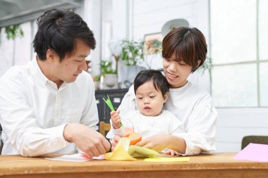 Ebeveyn ve çocuk evde origami oynuyorlar