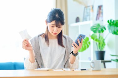 Elinde bir makbuz tutan şaşırmış bir yüzü olan genç bir kadın.