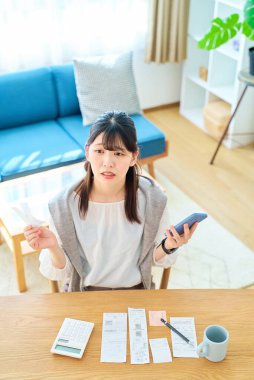 Elinde bir makbuz tutan şaşırmış bir yüzü olan genç bir kadın.