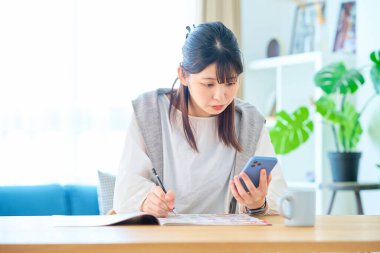 Odada reklam kitapçığını kontrol eden genç bir kadın.