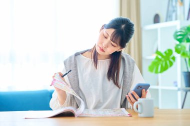 Odada reklam kitapçığını kontrol eden genç bir kadın.