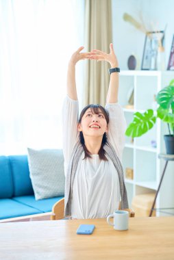 Genç bir kadın derin bir nefes alıyor. Parlak, sıradan bir yerde.