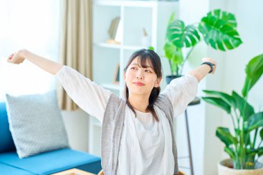 Genç bir kadın derin bir nefes alıyor. Parlak, sıradan bir yerde.