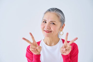 Kıdemli kadın odada barış işareti yapıyor.                   