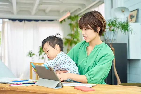 赤ちゃんと家で働く女性 — ストック写真