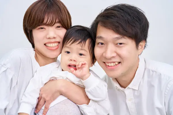 Aile gülümsüyor ve beyaz arka planda sıraya giriyor.