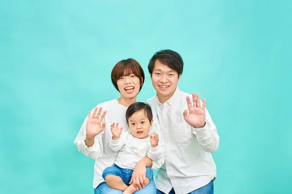 Una Famiglia Sorridente Che Agita Mani Davanti Uno Sfondo Blu — Foto Stock