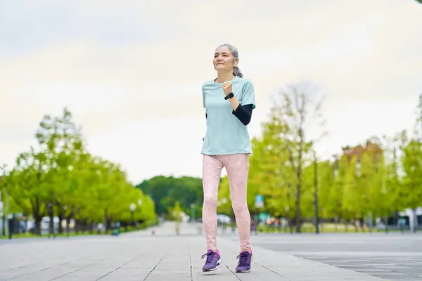 Energetic senior woman running in the city