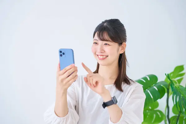 Junge Frau Schaut Drinnen Auf Smartphone Bildschirm — Stockfoto