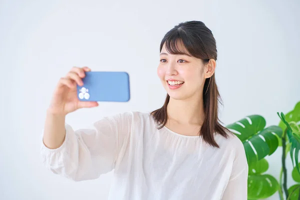 Junge Frau Schaut Drinnen Auf Smartphone Bildschirm — Stockfoto
