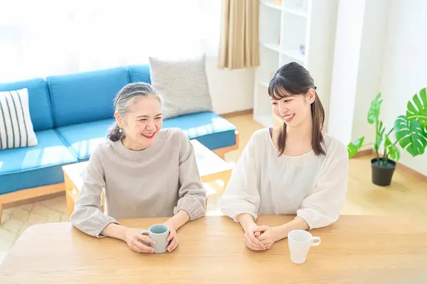 Seniorin Und Junge Frau Unterhalten Sich Freundlich Zimmer — Stockfoto