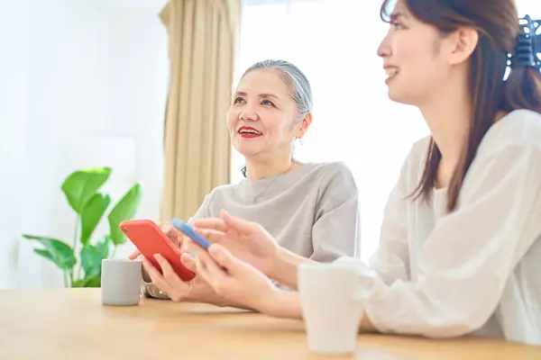 Seniorin Und Junge Frau Bedienen Smartphones Zimmer — Stockfoto